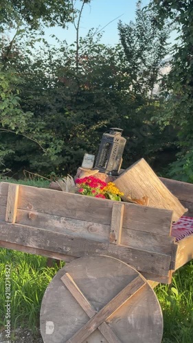 Rustic Wooden Cart Laden with Blooms: An antique wooden cart, filled with vibrant flowers and decorative items, sits idly by the roadside, evoking a sense of nostalgia and rustic charm.