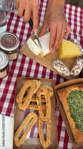 Italian Picnic Spread: A delightful assortment of cheeses, charcuterie, and pastries laid out on a classic red and white checkered tablecloth, ready for a perfect outdoor feast.