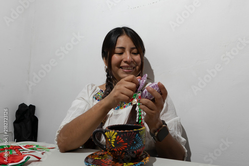 Canvas Print Mexican woman smiling and holding a decorative ceramic figure, showcasing tradit