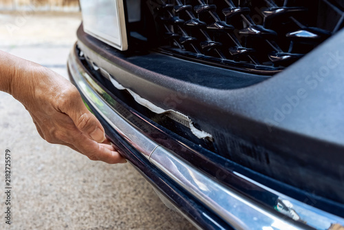фотографія Car owner check damaged front bumper skirt with hands