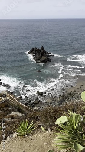 Vertical Shot of Benijo Beach in North Tenerife, Canary Islands, with Stairs and Dramatic Black Volcanic Sand Beach, Dark Rocky Formation and Crashing Waves if the Atlantic Ocean.