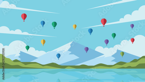 Multiple colorful hot air balloons float gracefully over a scenic landscape with snow-capped mountains and a calm blue lake at day.