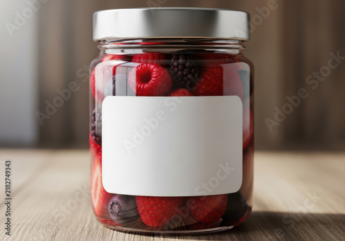 Glass jar filled with fresh mixed red berries and a blank white label