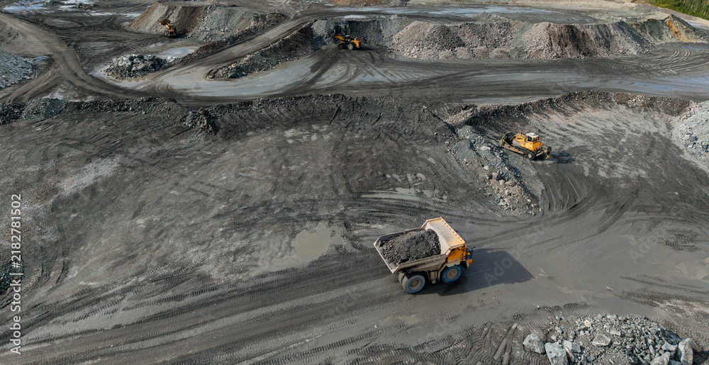 Obraz premium Open mining site with haul truck with gold and copper ore on road, Aerial view
