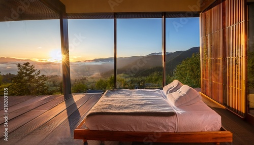 a peaceful spa bed faces large windows with a stunning sunrise view over serene mountain ranges creating a tranquil and relaxing atmosphere