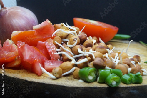 Bild auf Leinwand Fresh sprouted Bengal gram or whole chana sprouts on a wooden board with green c
