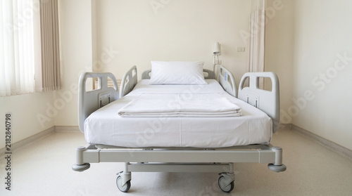 Obraz na płótnie Clean empty hospital bed in bright modern medical ward interior room
