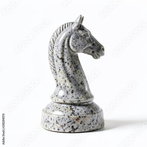Granite chess knight piece with finely detailed horse head and sturdy base on white background