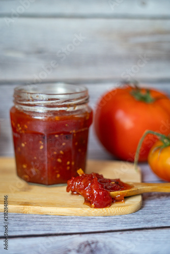 Homemade Tomato Jam in Glass Jar with Fresh Tomatoes