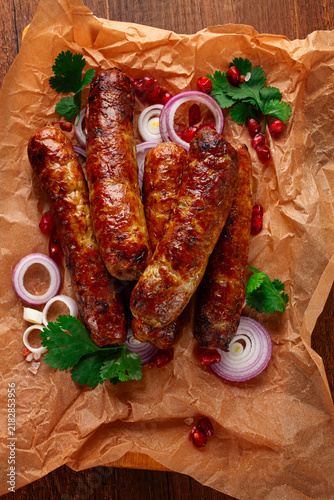 fried kupaty on parchment, with red onion and pomegranate, kupaty, Georgian cuisine,