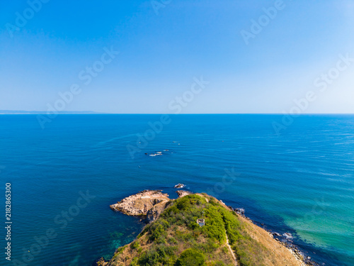 Canvastavla View of a coastal landscape with clear blue sky and calm waters at midday near a