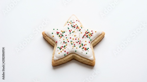 Star shaped sugar cookie with white icing and colorful sprinkles on a plain white background