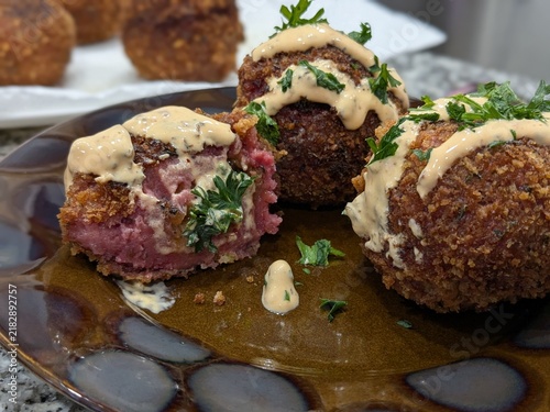 Bild auf Leinwand Crisp croquettes with creamy sauce and fresh parsley on a plate