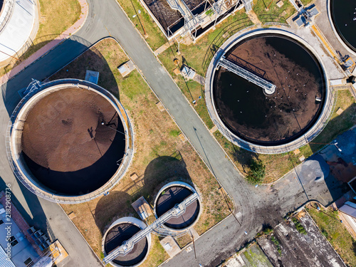 Fotografie Water treatment facility located near a city with several circular tanks arrange