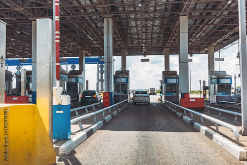 Toll road checkpoint, expressway entrance, highway payment booths with cars, transport infrastructure, traffic control, commuting, mobility and travel.