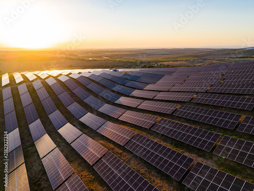 Foto Solar panels capture sunlight on a farm in the late afternoon near a valley with