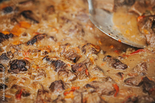 Фотография Close-up of beef stew simmering in a pot with tender meat pieces, colorful veget