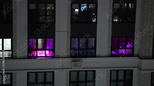 Pink LED lighting visible through building windows at night, suggesting controlled environment agriculture, indoor cultivation technology and modern urban growing solutions