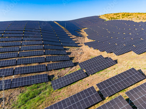 фотографія Solar panels cover a hillside in a renewable energy installation during daytime