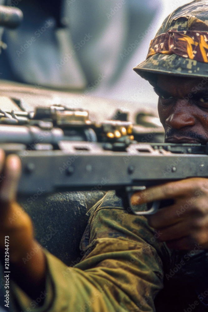 Obraz premium A soldier holding a machine gun, ready for action. vertical frame