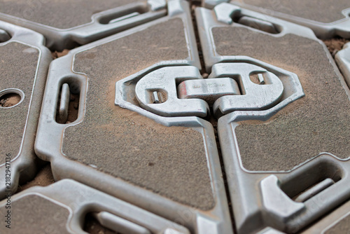 Fotografía Macro detail of the metal locking coupling that joins two hexagonal ground protection panels, dust settled in the moulded grooves