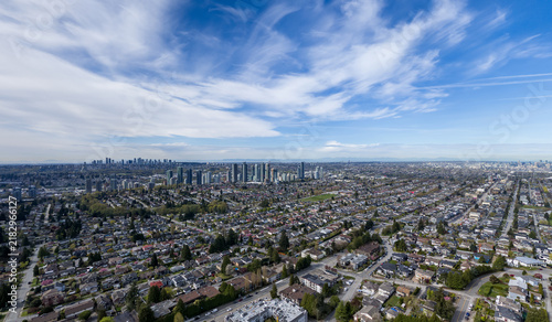 Aerial View of Vancouver City Skyline and Suburban Neighborhoods Under Blue Sky and Wispy Clouds