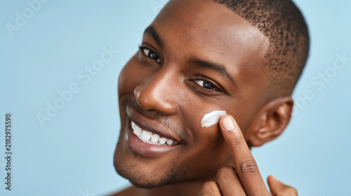 Young man applying face cream