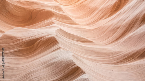 Smooth swirling layers of sandstone canyon walls illuminated by soft light