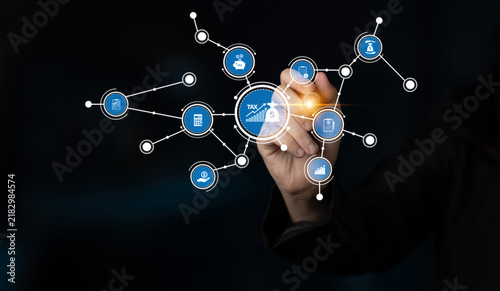Fotografie A business professional interacts with digital tax icons, illustrating modern finance and data management in a networked environment, showcasing technological innovation