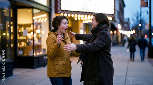 Two friends share a genuine moment of surprise reconnecting by chance