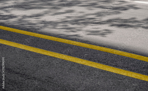 Quadro su tela Asphalt road surface with double yellow center lines