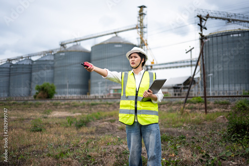 Cuadro en lienzo Female Engineer or Construction Inspector Monitoring Site with Factory Silos and