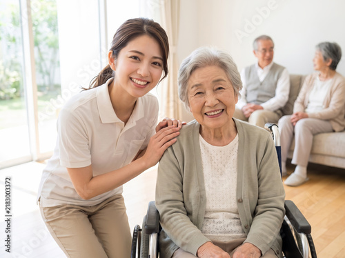 Naklejka 車椅子のシニア女性と笑顔で見守る若い介護スタッフ