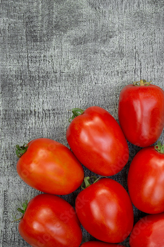 Ripe tomatoes with glossy skin against a seasonal harvest background, suitable for vegetarian food and ideal for retail.