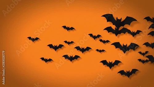 Black paper bats flying across vibrant orange background in this seasonal motion video animation clip design