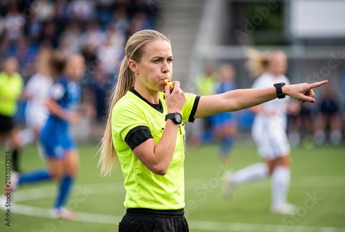 Female Football Referee Blowing Whistle and Pointing During Match