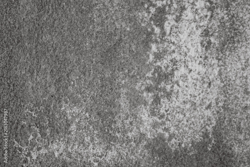 Grungy concrete wall with white efflorescence streaks and dark shadows, weathered, textured surface ideal as rugged and aged background