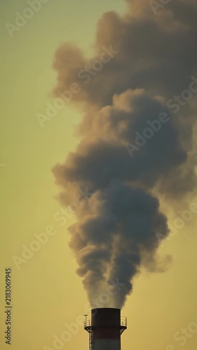 Industrial smoke stack releasing heavy dark pollution clouds into the atmosphere representing an environmental disaster