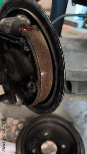 Foto Worn brake assembly sits exposed in garage setting