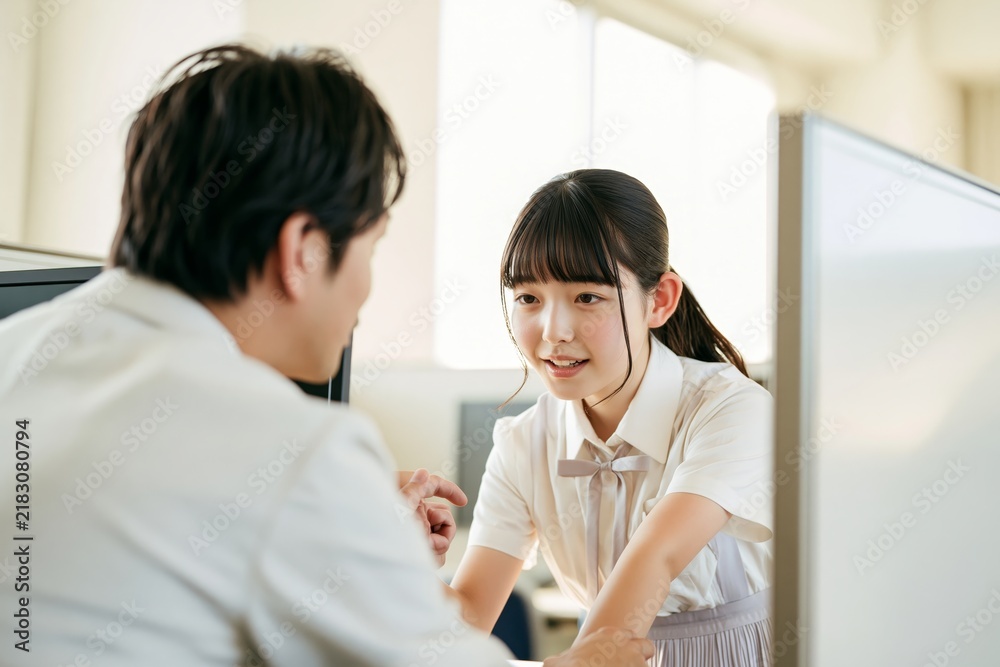 Obraz premium 日本の受験生が答案用紙に答えを書き込む、対話が伝わる構図