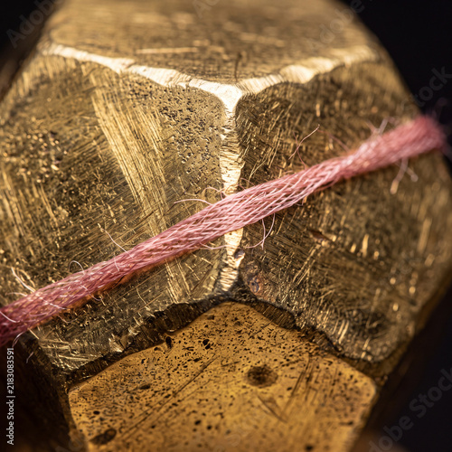 Golden Polyhedron With Rose Silk Thread Wrapping Edge On Dark Background, Macro Studio Lighting, High-End Commercial Detail