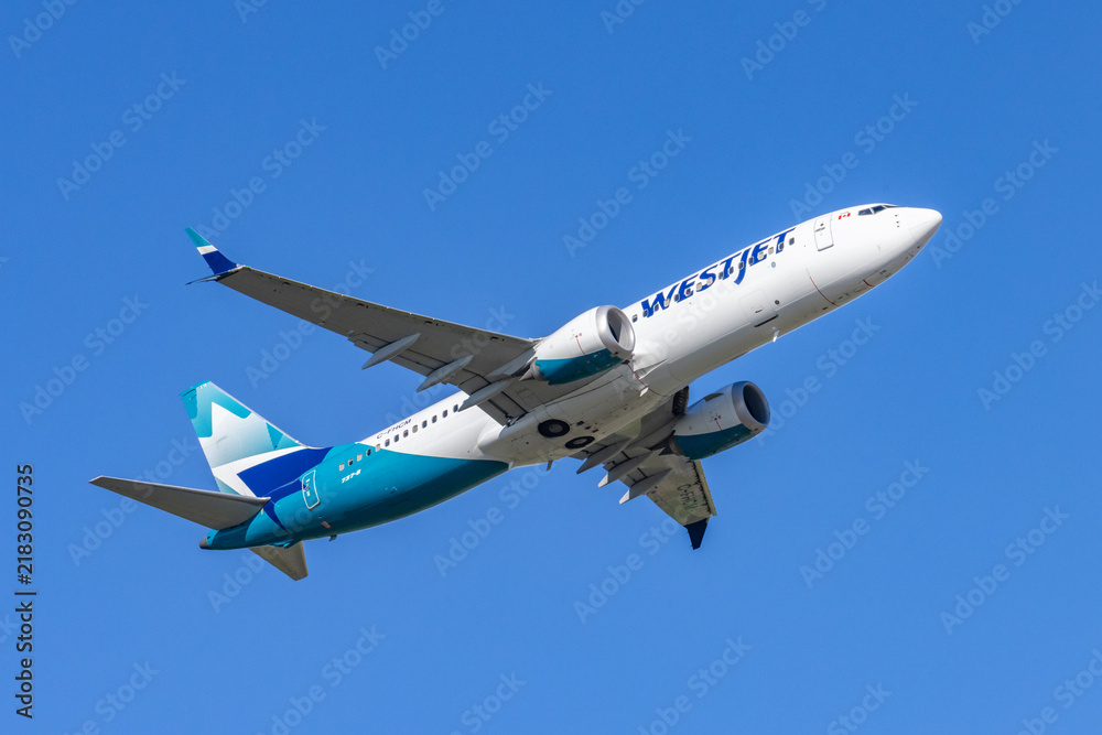 Obraz premium Toronto, Canada, September 6, 2026; WestJet Boeing 737-8 tail C-CFHCM taking off wheels up against a cloudless sky