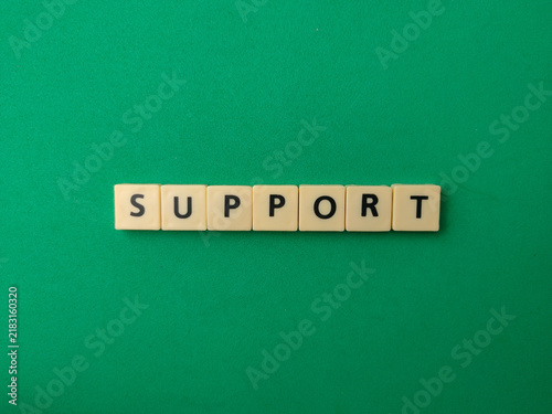 Letter tiles arranged horizontally spell the word SUPPORT in the center of a vibrant green background