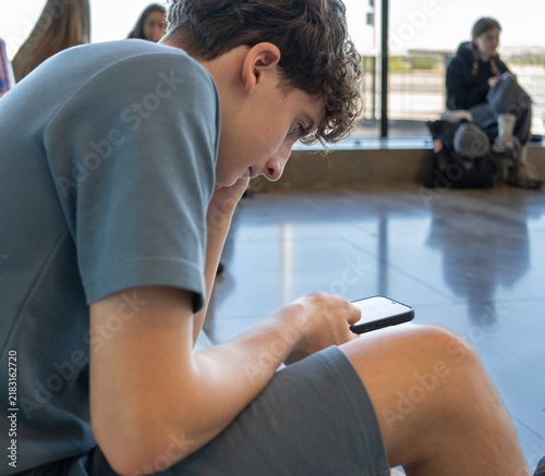 Fotografía Young man engrossed in phone content, representing youth and digital connection