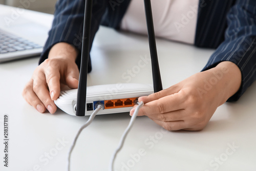 Foto Internet connectivity and network setup, person connecting ethernet cable to wir