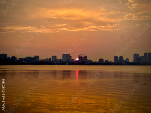 Golden Sunset Over Urban Water With Skyline and Red Reflection on West Lake in Hanoi, Vietnam