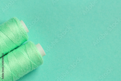 Фотография Spools of thread on turquoise background