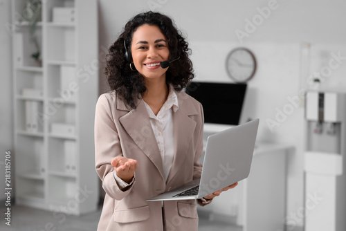Female African-American online business consultant with laptop in office