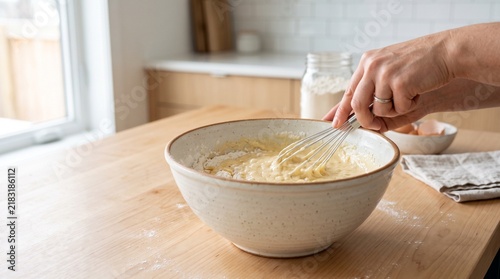 Hands preparing fresh homemade pasta dough in bowl.