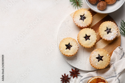 Fotografía Board of tasty Christmas mince pies with nuts and spices on white background